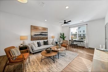 A living room with a couch and chairs and a ceiling fan